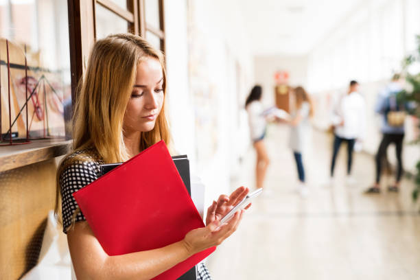 Teenage girl using phone in high school
source: Istockphoto.com